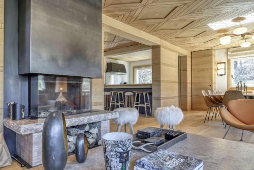 un salon avec une cheminée et une table dans l'établissement Chalet Boucle, à Megève
