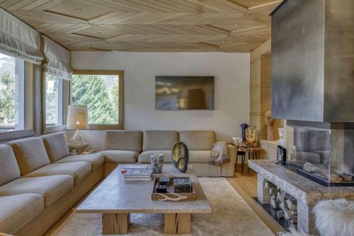 un salon avec un canapé et une cheminée dans l'établissement Chalet Boucle, à Megève