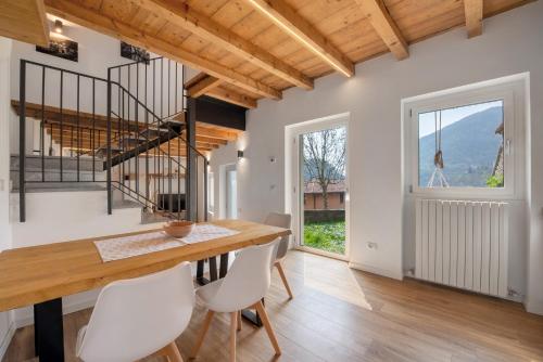 a dining room with a wooden table and white chairs at Family House Il Butto in Erve
