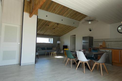 une cuisine et une salle à manger avec une table et des chaises dans l'établissement La Grange, à Cléder