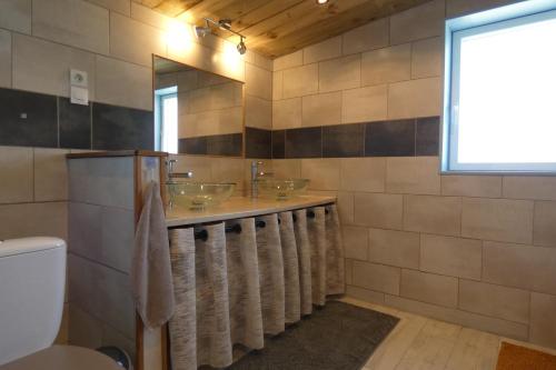 La salle de bains est pourvue de 4 lavabos et d'un miroir. dans l'établissement La Grange, à Cléder