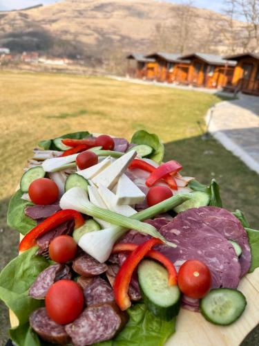 a plate of food with vegetables on a table at Pensiunea Bodrogeni in Poiana Aiudului