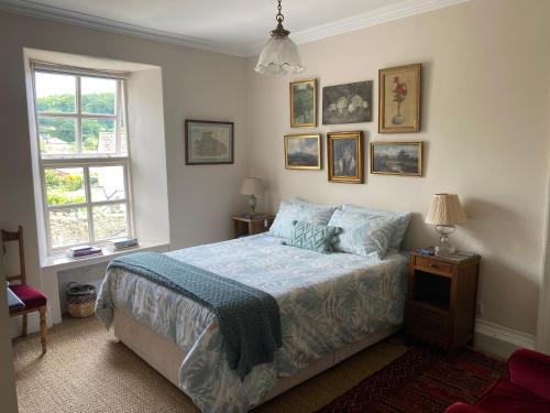 a bedroom with a bed with a blue comforter at Six on Castle in Tiverton