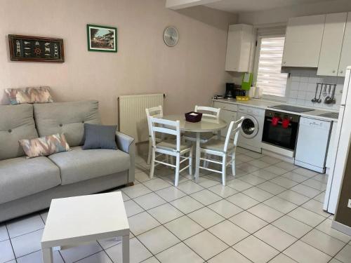 un salon avec un canapé et une table et une cuisine dans l'établissement Appartement cosy à Hendaye, 45 m², parking inclus, à Hendaye