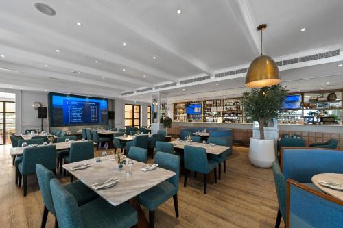 a restaurant with tables and chairs and a bar at Arabian Ranches Golf Club in Dubai