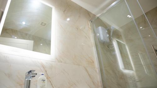 a bathroom with a shower and a mirror at Prestige Stays Cardiff Modern 1-Bed Apartment near City Centre Wi-Fi & Lockbox Check-In in Cardiff