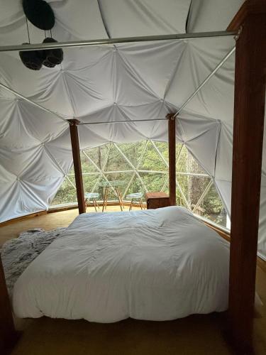 a bedroom with a canopy bed with a large window at MANDALA CAMP in Tomatlán