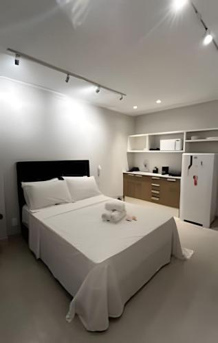 a white bedroom with a large bed and a refrigerator at Conforto e Praticidade - Centro do RJ in Rio de Janeiro