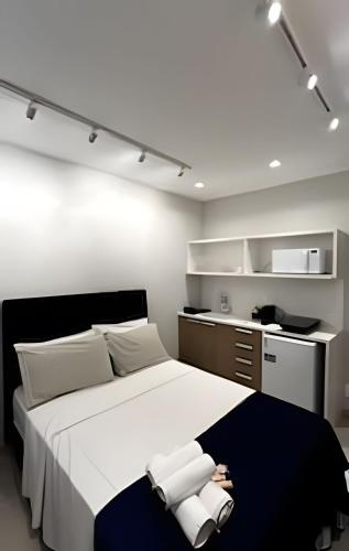 a bedroom with a large white bed with towels on it at Conforto e Praticidade - Centro do RJ in Rio de Janeiro