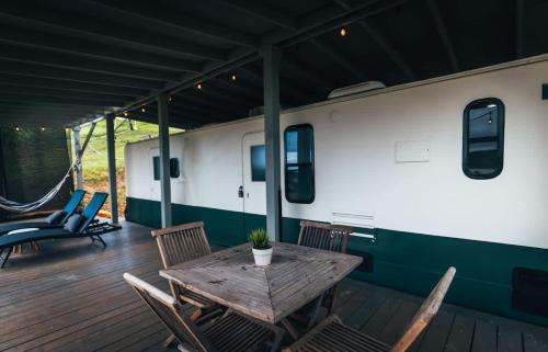 ein Holztisch und Stühle auf einer Terrasse in der Unterkunft Scenic Serene RV - Panoramic Views in Culebra