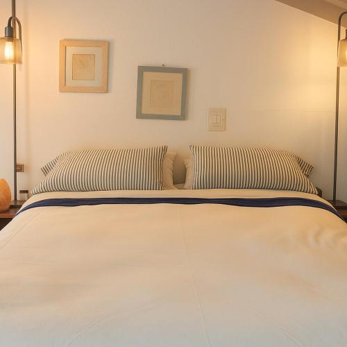 un grand lit blanc avec deux oreillers dessus dans l'établissement Magnifique maisonnette proche du centre-ville d Aix, à Aix-en-Provence