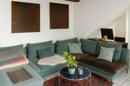 un salon avec un canapé bleu et une table dans l'établissement Magnifique maisonnette proche du centre-ville d Aix, à Aix-en-Provence