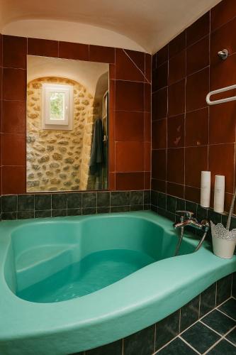 La salle de bains est pourvue d'une baignoire bleue et d'un miroir. dans l'établissement Magnifique maisonnette proche du centre-ville d Aix, à Aix-en-Provence
