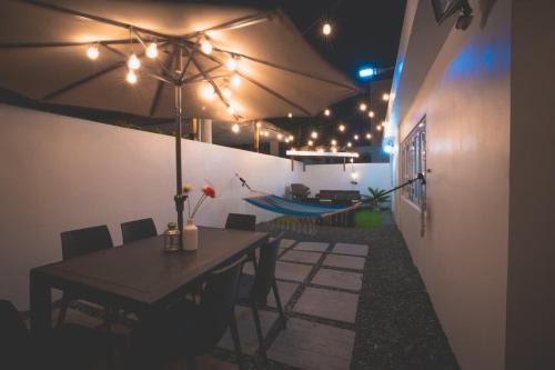 a patio with a table with an umbrella and lights at Romantic Dorado Beach Studio in Dorado