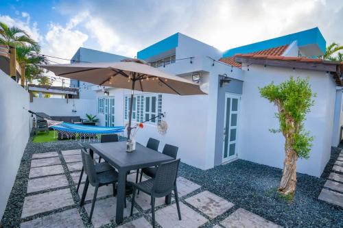 a patio with a table and chairs and an umbrella at Romantic Dorado Beach Studio in Dorado