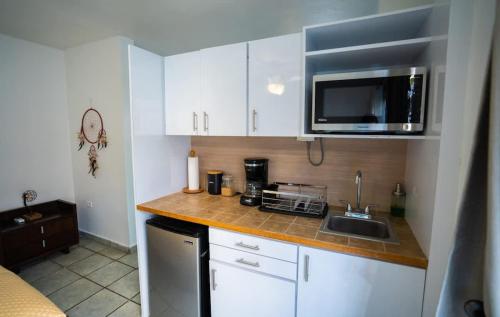 a small kitchen with a sink and a microwave at Romantic Dorado Beach Studio in Dorado