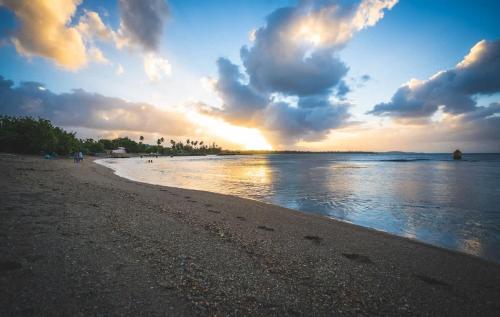 a beach with a cloudy sky and the ocean at Romantic Dorado Beach Studio in Dorado