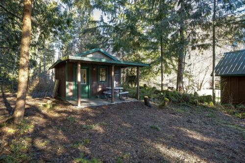 a small shed with a picnic table in the woods at Unique Glamping Experience, Pet Friendly, Sleeps 2 in Maple Falls