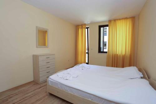 a bedroom with a white bed and a window at Sozopol Dreams Apartments in Sozopol