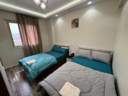 a bedroom with two beds and a window at 212 . Spacious 3BR Apt. 2 Baths Gated Community in Sheikh Zayed