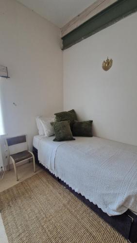a white bedroom with a bed and a chair at The Mill France- Near Millau in Saint-Georges-de-Luzençon