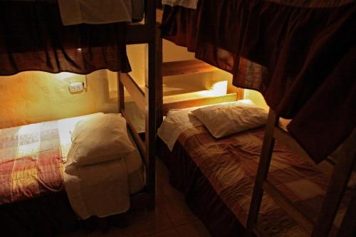 two bunk beds in a small room with a bed at Samay Wasi Hostel in Cusco