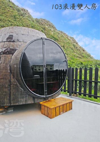 a large wooden object with a round window and a wooden table at wow夢想家會館 in Green Island