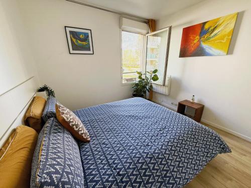 a bedroom with a blue bed and a window at uta house la plaine in Saint-Denis