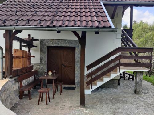 a patio with a wooden door and a table and stairs at Countryside house in Male Brusnice