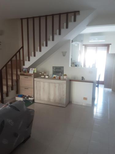 a living room with a staircase and a kitchen at B&B Il viaggio in Borghesiana 