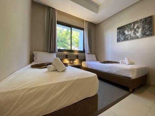 a hotel room with two beds and a window at alhoceima vip safiha in Al Hoceïma