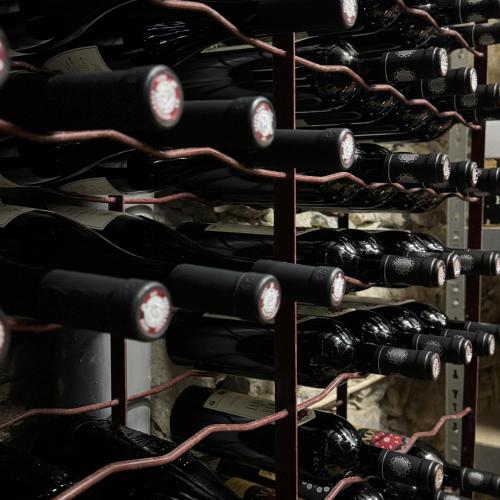 a bunch of wine bottles in a wine cellar at Hôtel Fleur des Alpes in La Brigue