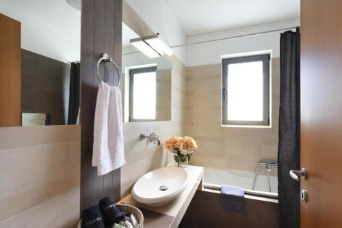 une salle de bain avec un lavabo, des toilettes et une baignoire dans l'établissement Saronida Seaside Serenity, à Saronida