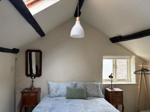 a bedroom with a bed and two night stands and a window at Six on Castle in Tiverton