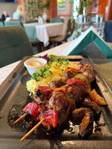 a plate of food with meat and vegetables on a table at Hotel Previla in Sarajevo