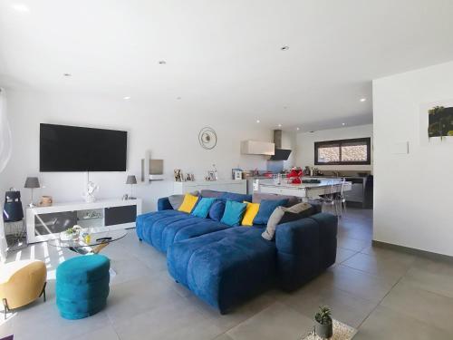 un salon avec un canapé bleu et une table dans l'établissement Villa Cami del Paradis, à Corneilla-del-Vercol