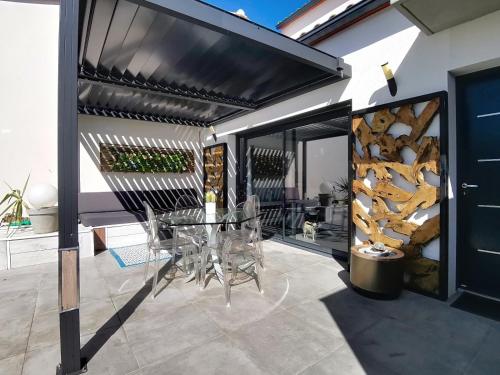 d'une terrasse avec une table et des chaises sous un auvent. dans l'établissement Villa Cami del Paradis, à Corneilla-del-Vercol