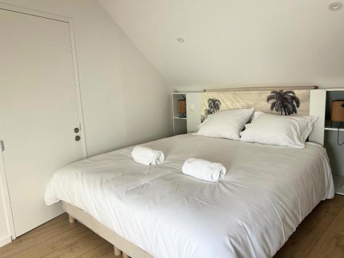 un grand lit blanc avec deux oreillers dessus dans l'établissement Ile de groix - T2 - centre-ville - TV, à Vannes