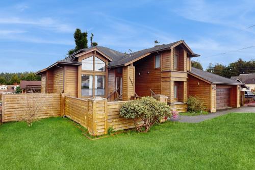 a wooden house with a fence in a yard at Tall Trees Lodge in Eureka