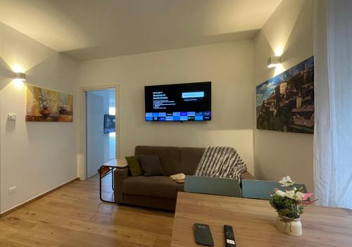 a living room with a couch and a tv on the wall at Orvieto Residence in Orvieto