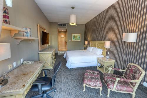 a hotel room with a bed and a desk and chairs at Holiday Inn Queretaro Centro Historico by IHG in Querétaro