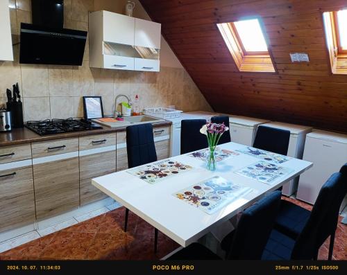 a kitchen with a table with a vase of flowers on it at Robitel Wellness Vendégház Veszprém-Gyulafirátót in Veszprém