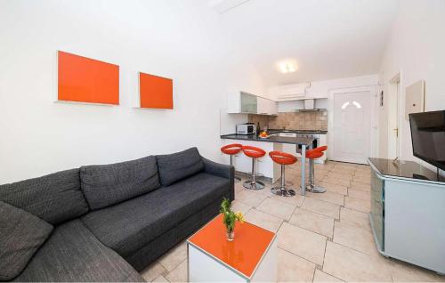 a living room with a gray couch and red stools at Nice Apartment In Vidalici in Kustići