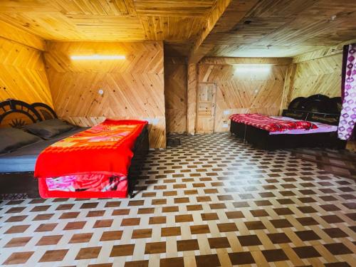 a room with two beds in a wooden room at Pahadibliss hostel tosh in Tosh