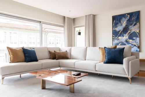 a living room with a white couch and a coffee table at The Eight Luxury Stay in Penafiel