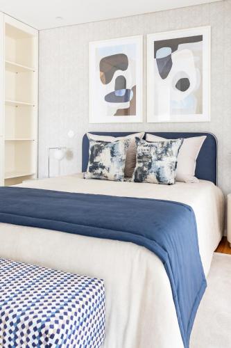 a bedroom with a blue and white bed with paintings at The Eight Luxury Stay in Penafiel