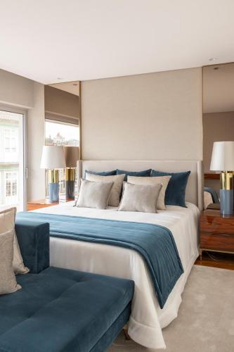 a large bedroom with a large bed with blue sheets at The Eight Luxury Stay in Penafiel