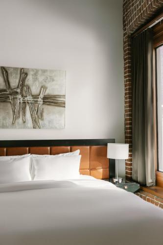 a bedroom with a white bed and a window at Lofts du Vieux-Port by Gray Collection in Montréal