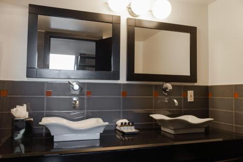 a bathroom with two sinks and a mirror at Lofts du Vieux-Port by Gray Collection in Montréal