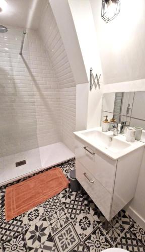 une salle de bain blanche avec un lavabo et une douche dans l'établissement Les Bons Enfants 8, à Rouen